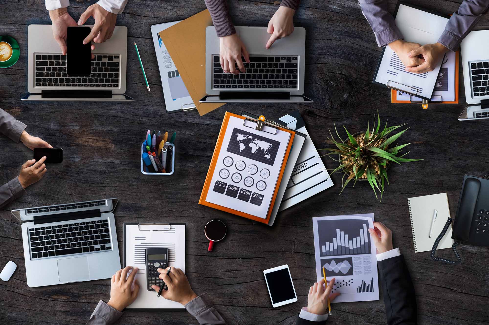 Marketing reports and laptops on a desk during a strategy review